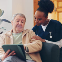 a man pointing his tablet to his caretaker