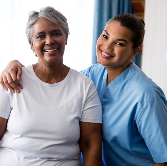 female caretaker and elderly woman smiling