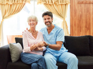 Smiling caregiver holding senior woman's hand