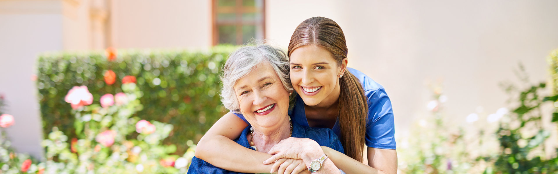 Shot of a resident and a nurse outside in the retirement home garden.